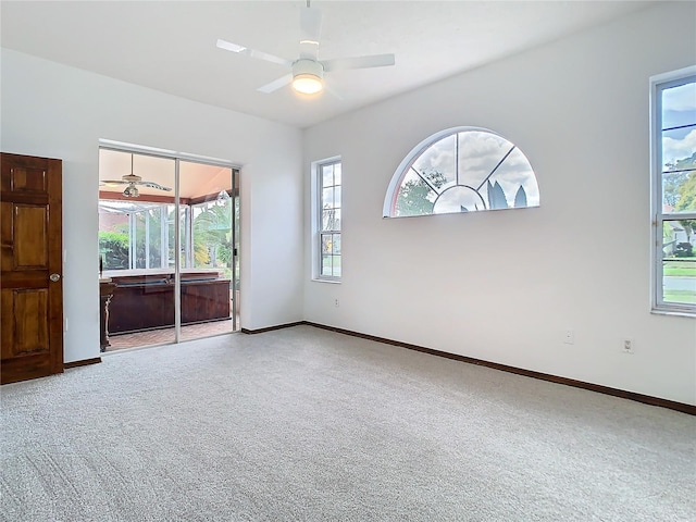 unfurnished room with carpet flooring, a ceiling fan, and baseboards