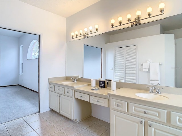 full bath featuring double vanity, a sink, and tile patterned floors