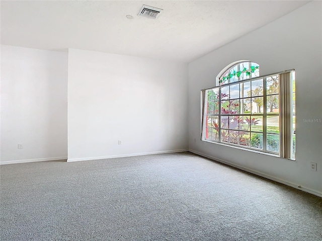 carpeted empty room featuring visible vents and baseboards