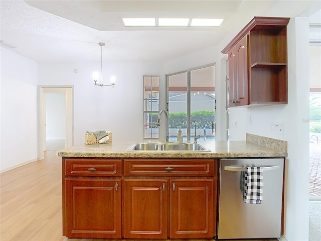 kitchen featuring light wood-style floors, light countertops, a sink, and stainless steel dishwasher