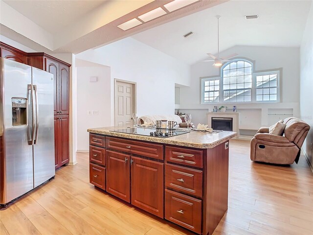 kitchen with light wood-style floors, black electric stovetop, light countertops, and stainless steel fridge with ice dispenser