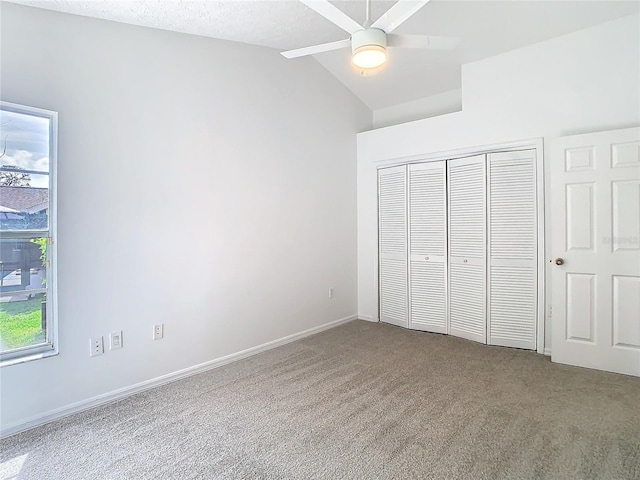 unfurnished bedroom featuring baseboards, a ceiling fan, vaulted ceiling, carpet floors, and a closet