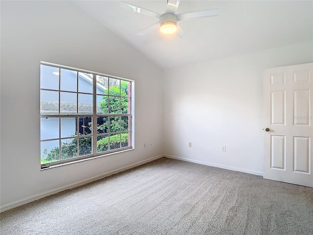 carpeted empty room with vaulted ceiling, a ceiling fan, and baseboards