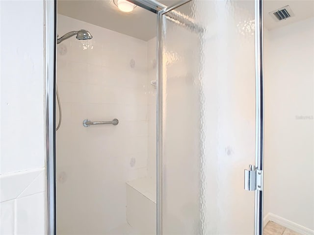 bathroom with a stall shower and visible vents