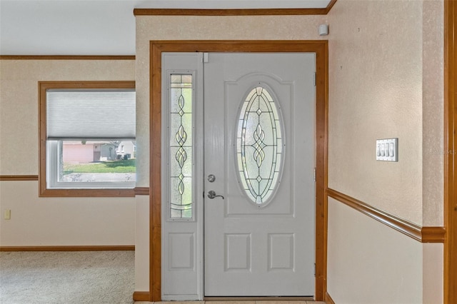 entryway featuring baseboards, carpet floors, and ornamental molding