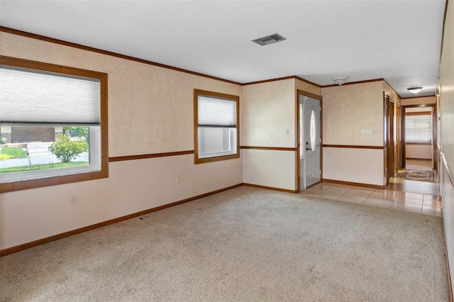 unfurnished room with crown molding, baseboards, visible vents, and light carpet