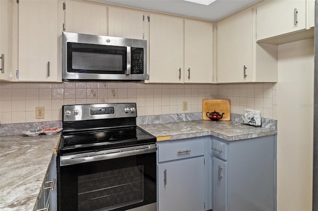 kitchen with light countertops, backsplash, and appliances with stainless steel finishes