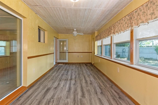 unfurnished sunroom featuring visible vents, wood ceiling, and a ceiling fan