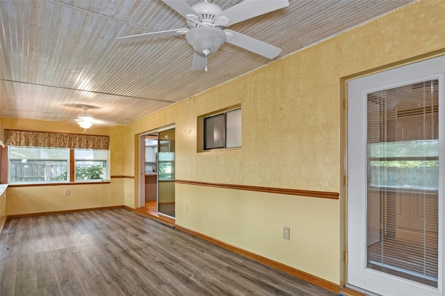 spare room with baseboards, wood finished floors, and a ceiling fan