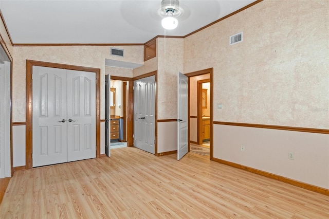 unfurnished bedroom with light wood-style flooring, baseboards, visible vents, and ornamental molding