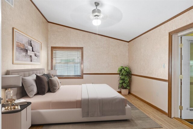 bedroom with baseboards, wood finished floors, visible vents, and ornamental molding