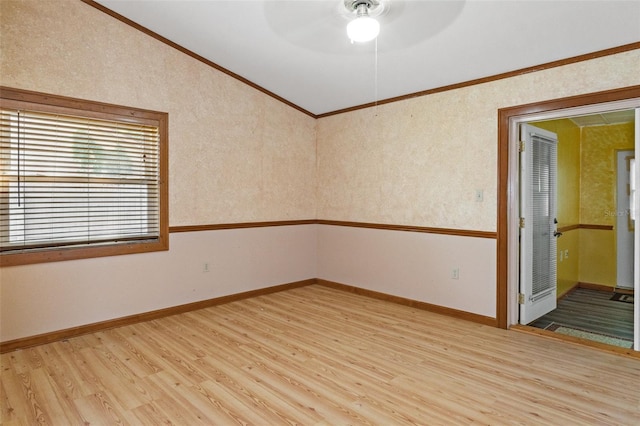 unfurnished room featuring a ceiling fan, light wood-style floors, crown molding, wallpapered walls, and baseboards