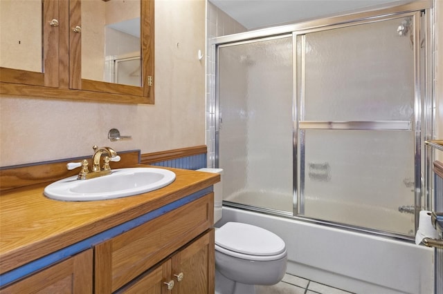 bathroom with tile patterned floors, shower / bath combination with glass door, vanity, and toilet