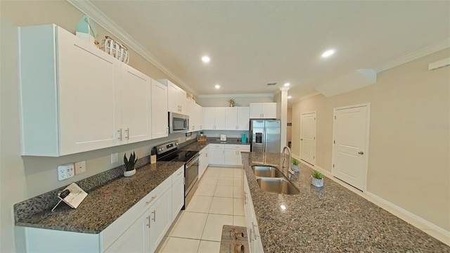 31941 Blue Passing Loop, Wesley Chapel, FL 33545 - kitchen featuring appliances with stainless steel finishes, a sink, crown molding, white cabinetry, and dark stone counters