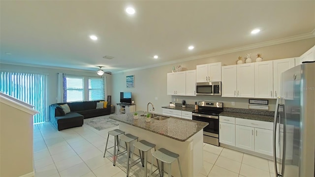 kitchen with white cabinetry, sink, ceiling fan, appliances with stainless steel finishes, and a center island with sink