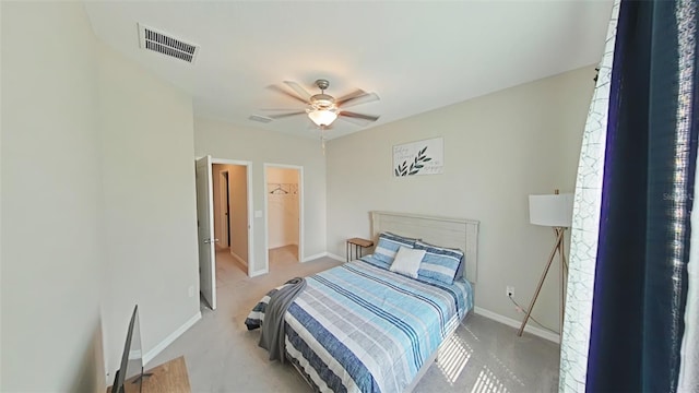 carpeted bedroom featuring a spacious closet, ceiling fan, and a closet