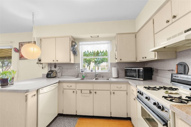 kitchen featuring white appliances, cream cabinets, tasteful backsplash, and sink