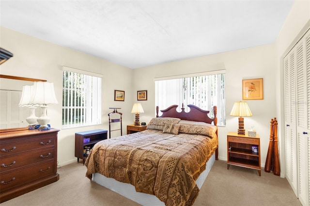 carpeted bedroom featuring a closet and multiple windows