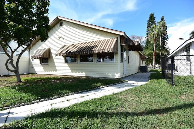 view of front of house featuring cooling unit and a front lawn