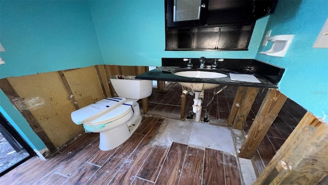 bathroom featuring toilet, wood-type flooring, and sink