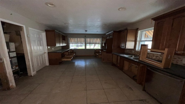 kitchen with a wealth of natural light, backsplash, and light tile patterned floors