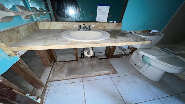 bathroom featuring toilet, sink, and tile patterned flooring