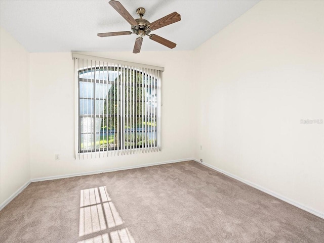 carpeted spare room with ceiling fan