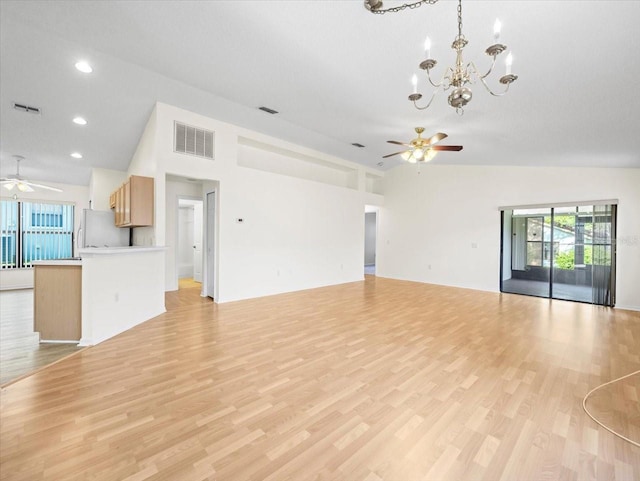 unfurnished living room with ceiling fan with notable chandelier, light hardwood / wood-style flooring, and high vaulted ceiling