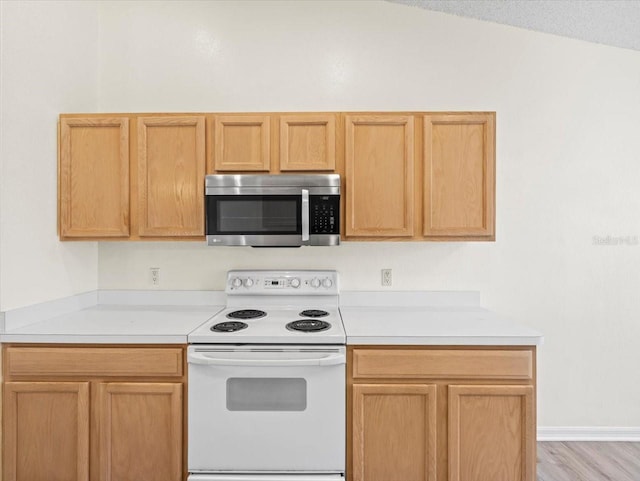 kitchen with light hardwood / wood-style floors, lofted ceiling, white electric range, and light brown cabinets