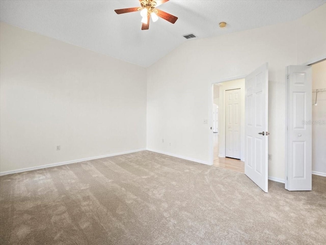 unfurnished room with lofted ceiling, light carpet, and ceiling fan