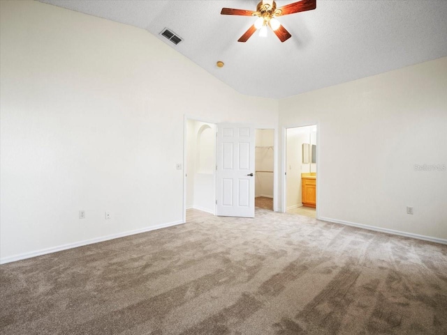 unfurnished bedroom with carpet, ensuite bath, ceiling fan, and high vaulted ceiling