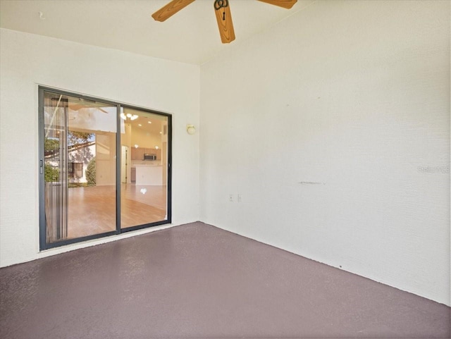 spare room featuring ceiling fan and concrete floors