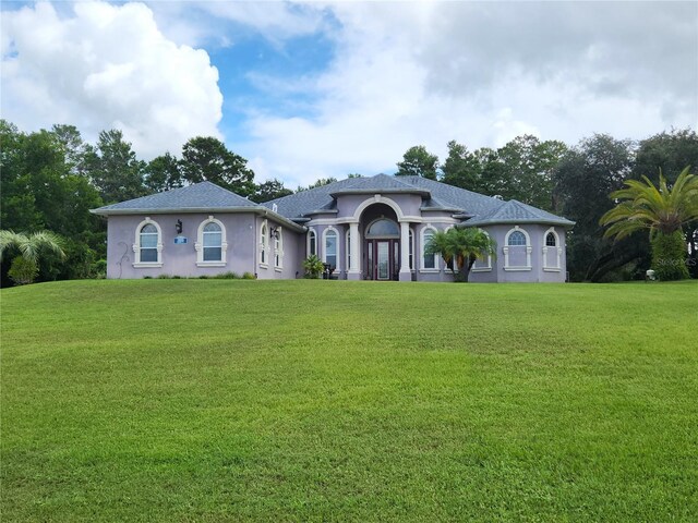 mediterranean / spanish home featuring a front lawn