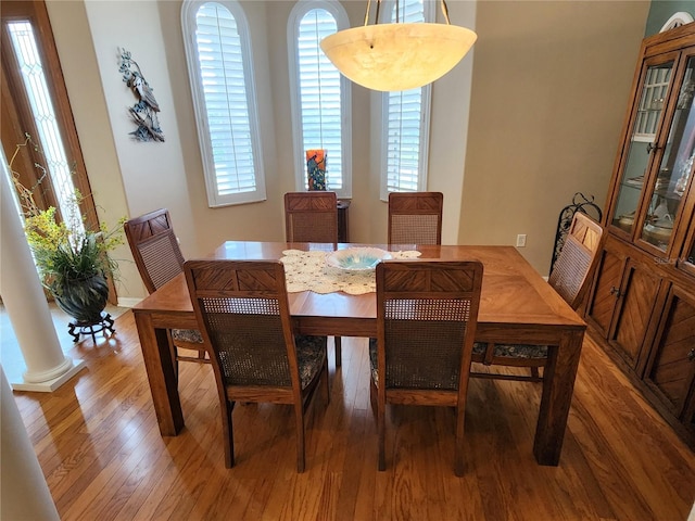 dining room with decorative columns and dark hardwood / wood-style floors