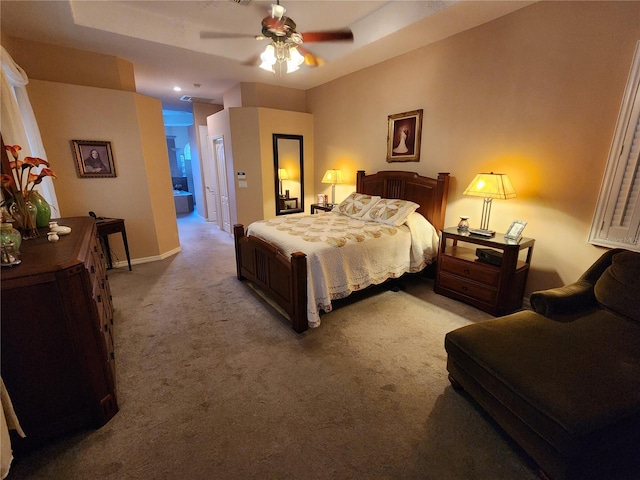 bedroom with ceiling fan, ensuite bathroom, and carpet floors