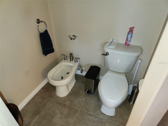 bathroom with tile patterned flooring, toilet, and a bidet