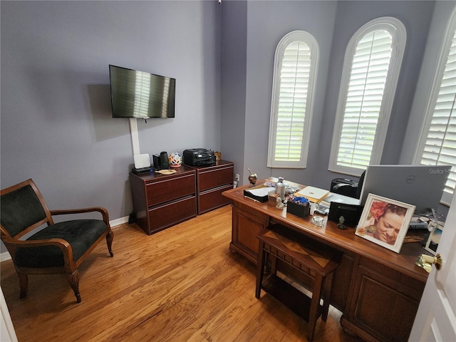 home office with a wealth of natural light and light hardwood / wood-style floors