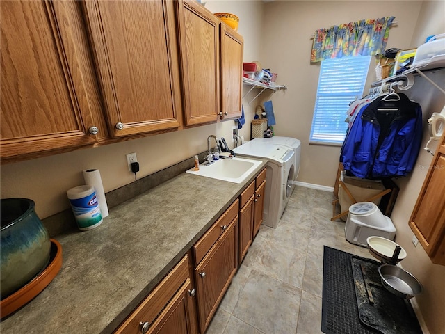 laundry room featuring independent washer and dryer, cabinets, and sink