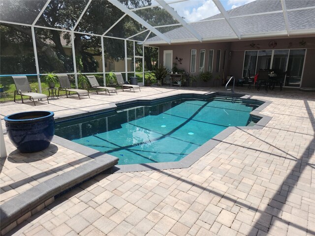 view of swimming pool with a lanai and a patio