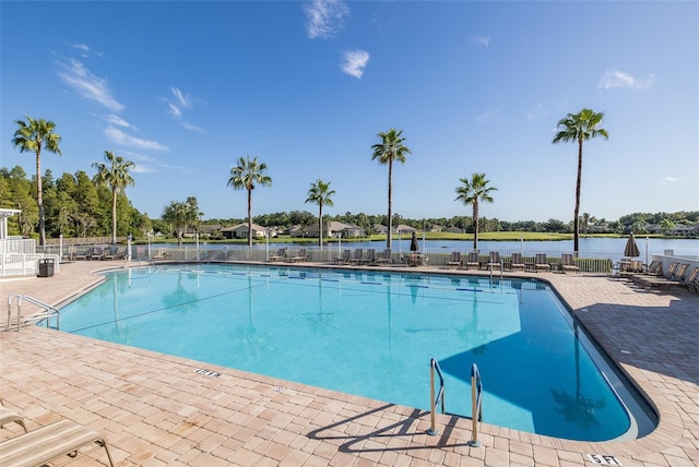 view of swimming pool with a water view and a patio area