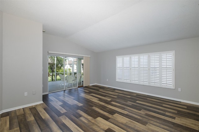 spare room featuring vaulted ceiling, a textured ceiling, and dark hardwood / wood-style flooring