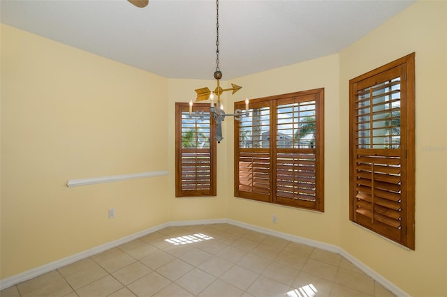 unfurnished room featuring light tile patterned floors and a notable chandelier