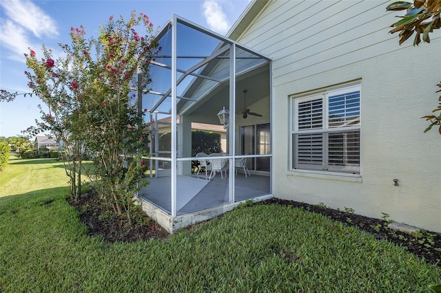 exterior space featuring a lanai, a yard, a patio area, and ceiling fan