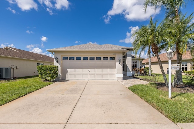 view of front of property featuring a garage, central air condition unit, and a front lawn