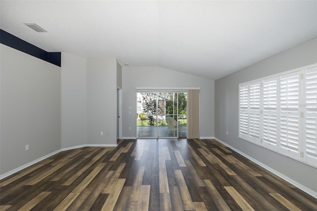 unfurnished room with a textured ceiling, lofted ceiling, and dark hardwood / wood-style flooring