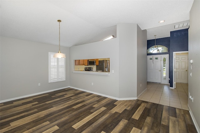 interior space featuring a chandelier, dark hardwood / wood-style flooring, and high vaulted ceiling