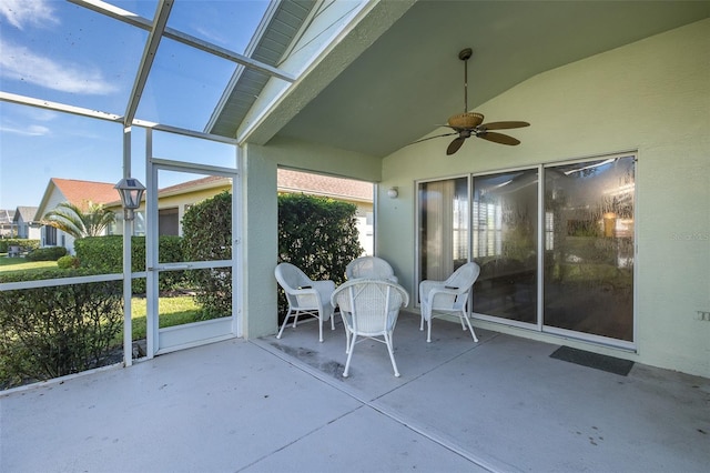 unfurnished sunroom featuring ceiling fan and vaulted ceiling with skylight