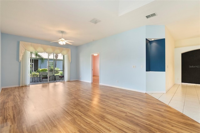 unfurnished living room with light wood-style floors, baseboards, visible vents, and a ceiling fan