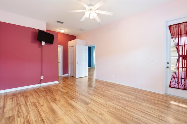 unfurnished room with light wood-style floors, visible vents, baseboards, and a ceiling fan