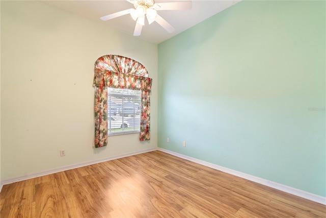 spare room with baseboards, ceiling fan, and light wood-style floors